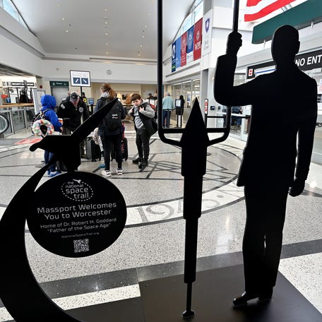 A century after Robert H. Goddard ignited the world’s first liquid-fueled rocket, Worcester Regional Airport marked the milestone on March 3 with the dedication of a dramatic new 12-foot steel “silhouette” of Goddard standing next to his rocket. The permanent display is located on the second floor of the terminal, named Goddard Hall.