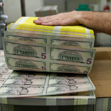 Sheets of former U.S. President Abraham Lincoln on the five-dollar bill currency are fanned out at the Bureau of Engraving and Printing in Washington March 26, 2015