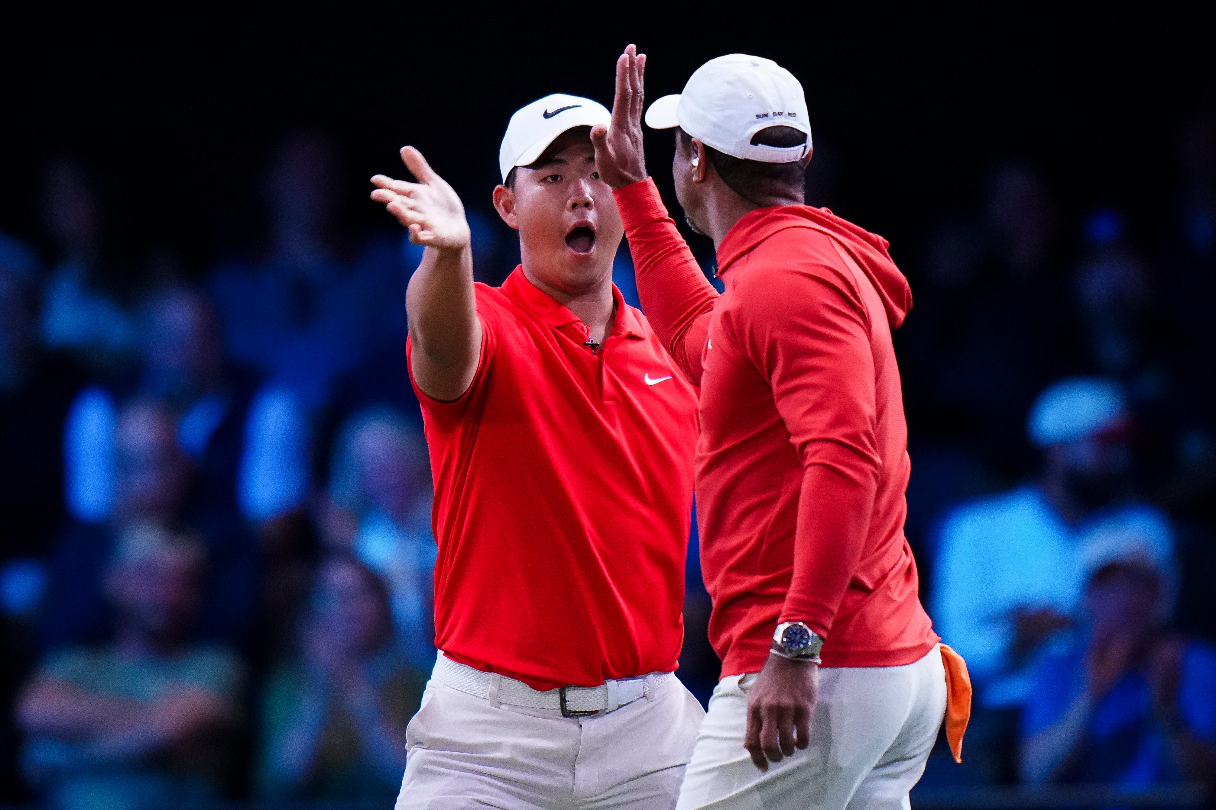 PALM BEACH GARDENS, FLORIDA - MARCH 03: Tom Kim of Jupiter Links GC high-fives Tiger Woods of Jupiter Links GC after the sixth hole during a match against The Bay Golf Club at SoFi Center on March 03, 2026 in Palm Beach Gardens, Florida. (Photo by Rich Storry/TGL/TGL Golf via Getty Images)