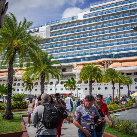Tourists pass a cruise ship docked on St. Thomas, U.S. Virgin Islands, October 22, 2025.