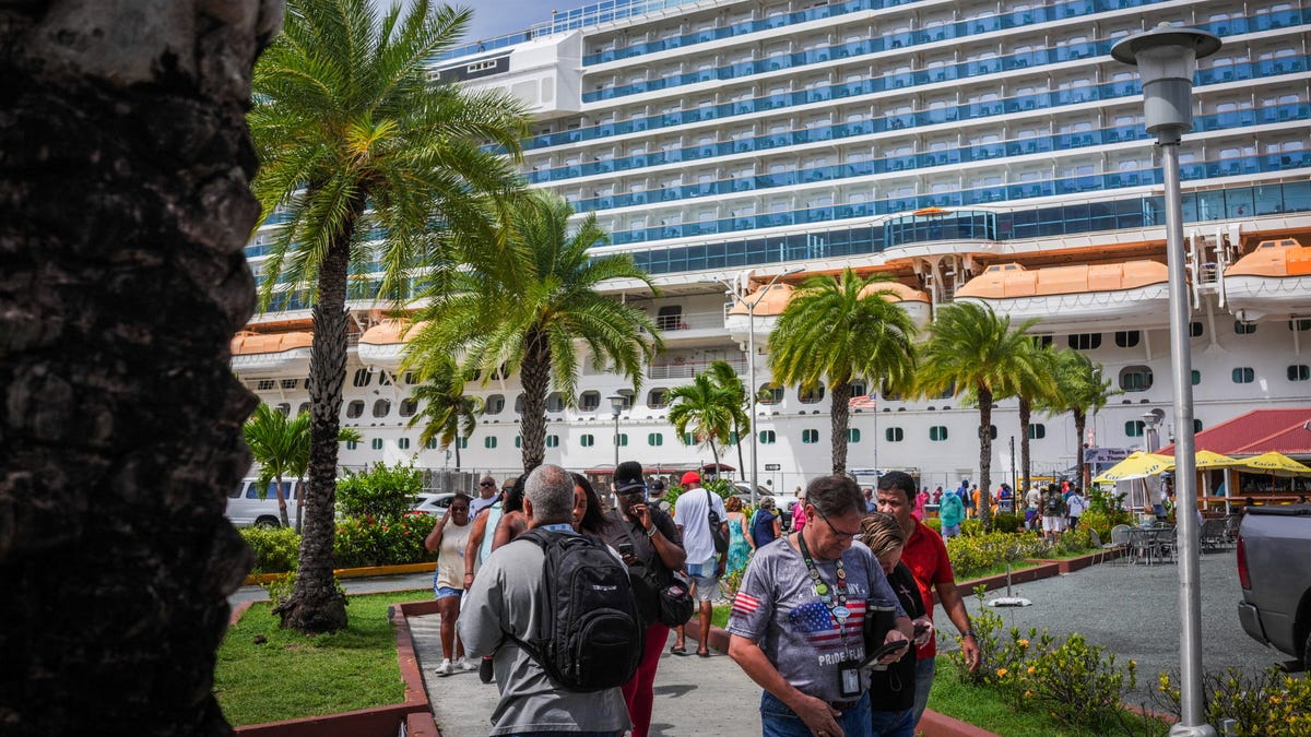 Tourists pass a cruise ship docked on St. Thomas, U.S. Virgin Islands, October 22, 2025.