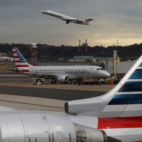 A jet from American Eagle, a regional branch of American Airlines (AA), takes off past other AA aircraft at Ronald Reagan Washington National Airport.