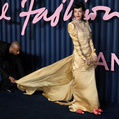 An assistant adjusts Lily Allen's dress as she attends The Fashion Awards 2025 at the Royal Albert Hall in London, Britain, Dec. 1, 2025.