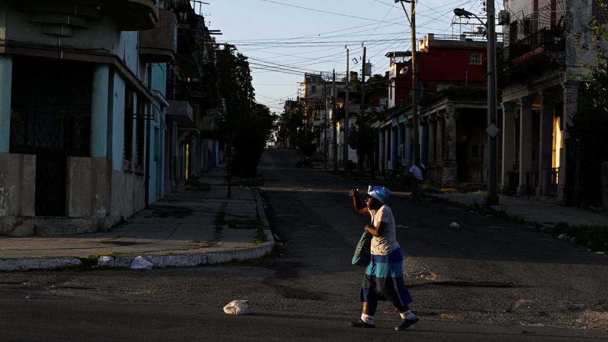 A woman walks on the street as Cuba brought its national electrical grid back online after the country had been largely without power for 16 hours in an outage that Energy Ministry officials linked to the oil blockade of Cuba imposed by the United States, in Havana, Cuba, March 5, 2026. REUTERS/Norlys Perez