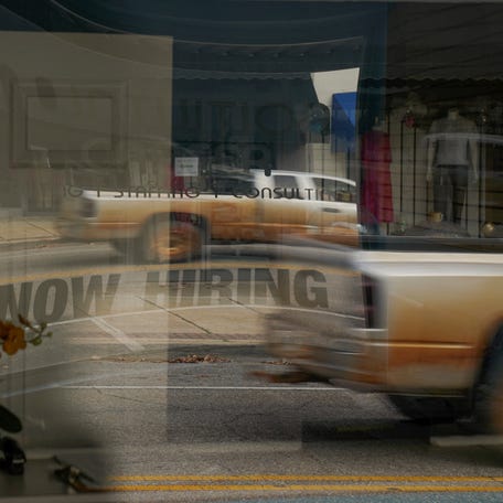 A "Now Hiring" sign is reflected through the window of Intuition Career staffing agency in Greenville, Alabama, U.S., December 4, 2022. REUTERS/Cheney Orr