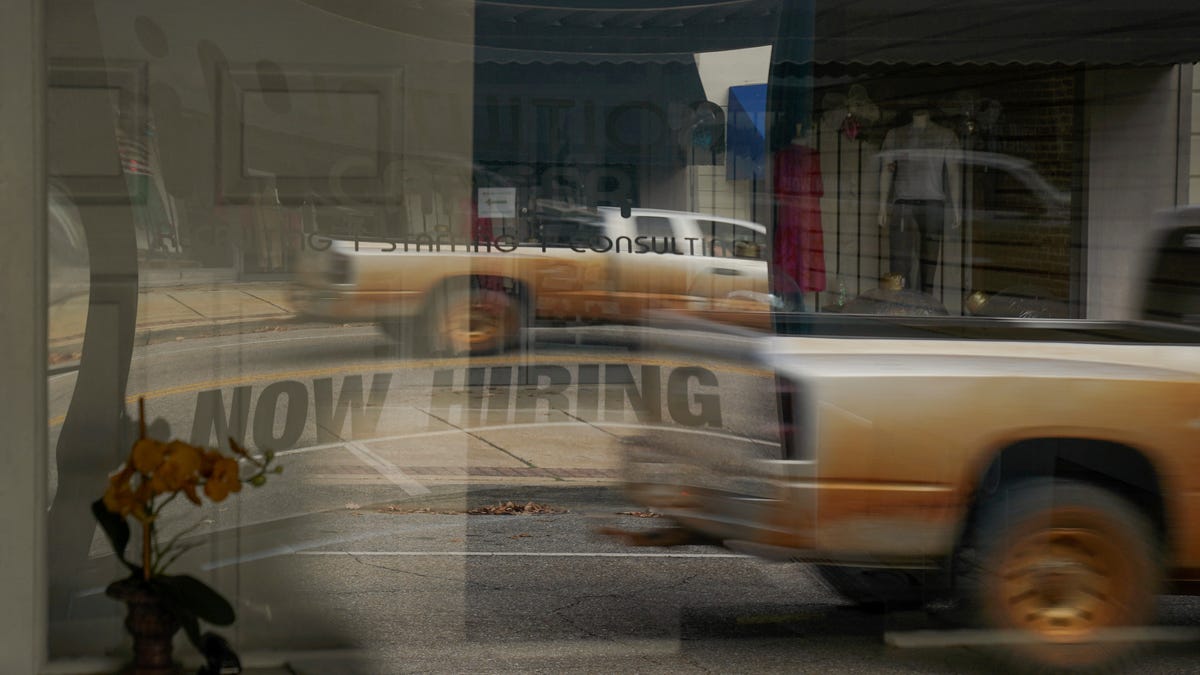 A "Now Hiring" sign is reflected through the window of Intuition Career staffing agency in Greenville, Alabama, U.S., December 4, 2022. REUTERS/Cheney Orr