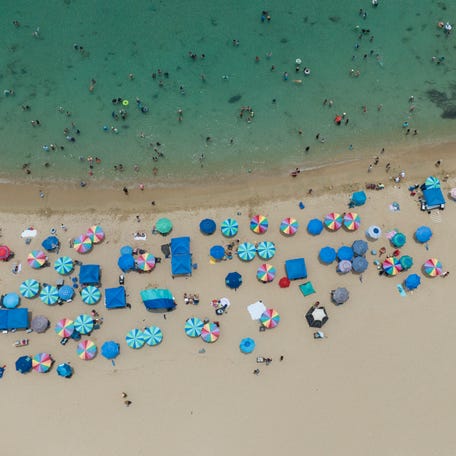 This aerial view shows people at the beach in Vega Baja, Puerto Rico, the municipality where Puerto Rican singer Bad Bunny grew up, on July 13, 2025.