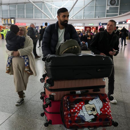 A man walks with luggage, as passengers from the first government‑chartered flight for British nationals, which departed from Oman, arrive at London Stansted Airport, amid the U.S.-Israeli conflict with Iran, near London, Britain, March 6, 2026.