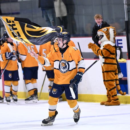 Littleton senior Gavin Werling waves a Tigers flag after the Division 4 boys hockey state semifinals Saturday at Loring Arena in Framingham. Littleton prevailed 5-1.
