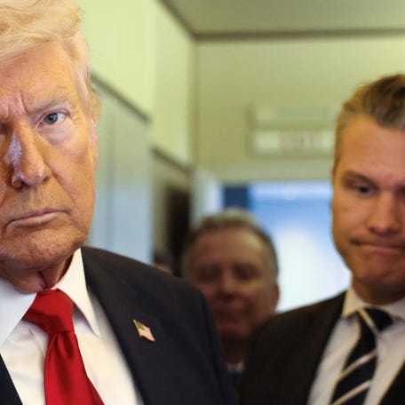U.S. President Donald Trump, with Secretary of Defense Pete Hegseth at his side, looks on as he speaks to reporters aboard Air Force One on a flight from Dover, Delaware, to Miami, Florida, U.S., March 7, 2026.