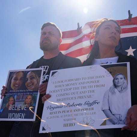 Sky Roberts, brother of Virginia Roberts Giuffre, and Amanda Roberts, sister in law of Virginia Roberts Giuffre, hold signs outside Zorro Ranch, a property formerly owned by Jeffrey Epstein, on International Women’s Day near Stanley, N.M., March 8, 2026.