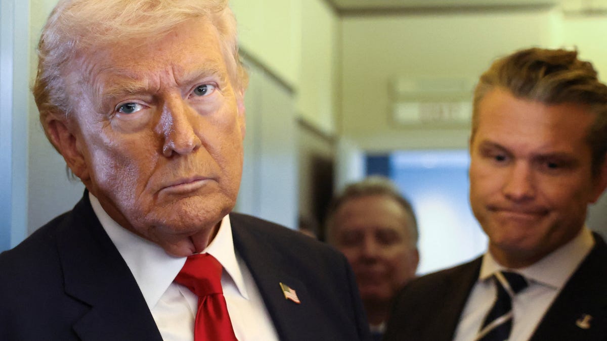 U.S. President Donald Trump, with Secretary of Defense Pete Hegseth at his side, looks on as he speaks to reporters aboard Air Force One on a flight from Dover, Delaware, to Miami, Florida, U.S., March 7, 2026.