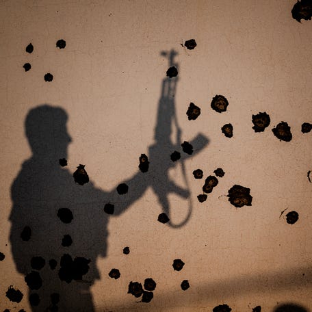 The shadow of a Kurdish fighter, a member of The Organization of Iranian Kurdistan Struggle (Sazmani Khabat), falls on the shrapnel scarred wall of a damaged building, following an Iranian drone attack to their base near Erbil, in Iraq's northern autonomous Kurdish region on March 9, 2026.