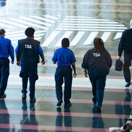 Transportation Security Administration agents walk through Ronald Reagan National Airport in Arlington, Virginia, on March 9, 2026.