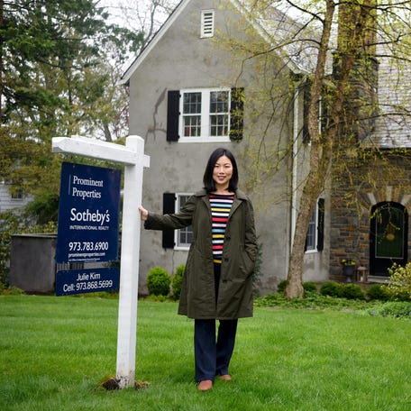 A real estate agent in front of a home for sale in New Jersey. How is the housing market doing?
