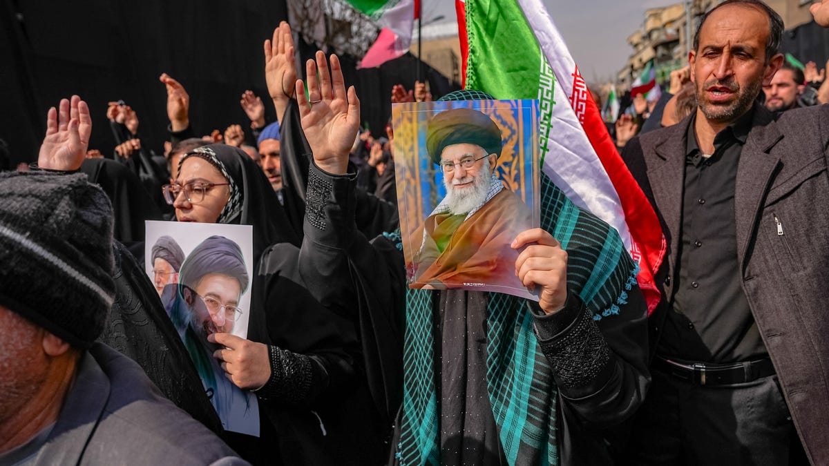 A person holds a picture of the late Ayatollah Ali Khamenei at Enghelab (Revolution) Square in Tehran on March 11, 2026.