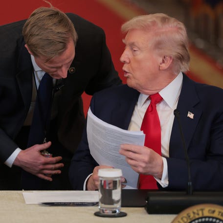 WASHINGTON, DC - MARCH 06: U.S. President Donald Trump (R) speaks to a U.S. Secret Service agent during a roundtable discussion on college sports in the East Room of the White House on March 06, 2026 in Washington, DC. The Trump administration held the roundtable titled "Saving College Sports" with leaders from the Power Four conferences, media executives and former coaches. (Photo by Anna Moneymaker/Getty Images)