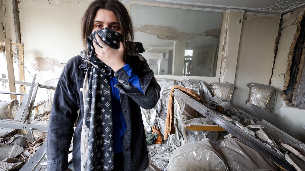 A woman inspects the damage inside her apartment after it was hit by an airstrike, amid the U.S.-Israeli conflict with Iran, in Tehran, Iran, March 12, 2026.