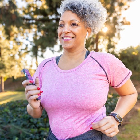 A beautiful woman walking with a fitness tracker.