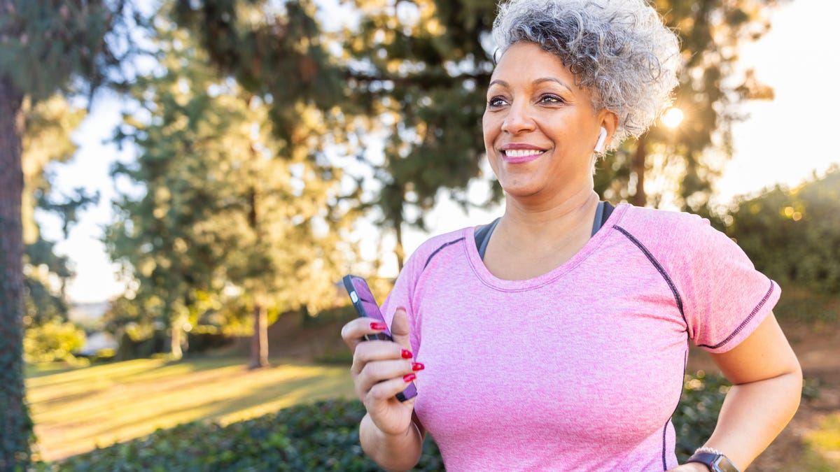 A beautiful woman walking with a fitness tracker.