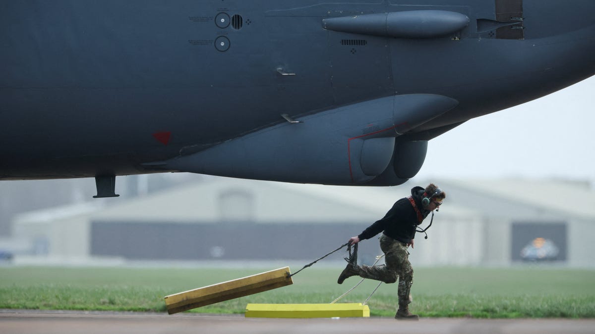 A member of the ground crew removes wheel chocks from a U.S. Air Force Boeing B-52 Stratofortress after it landed at the RAF Fairford airbase amid the U.S.–Israeli conflict with Iran, in Fairford, Britain, March 13, 2026.