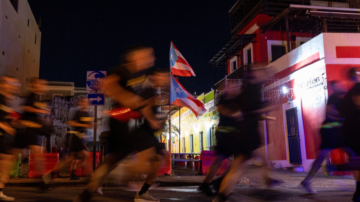 Puerto Rican flags wave as soldiers assigned to the U.S. Army Reserve's 1st Mission Support Command jog along a public route during the annual Caribbean Army Week in San Juan, Puerto Rico, January 9, 2026. REUTERS/Ricardo Arduengo