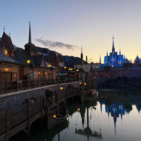 The World of Frozen begins to glow as night falls at Disney Adventure World.
