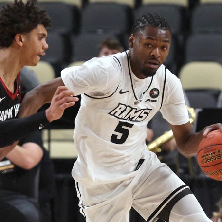 VCU Rams forward Barry Evans (5) brings the ball up court up court against pressure from Saint Joseph's Hawks guard Austin Williford (left) during the second half in an Atlantic 10 Conference Tournament semifinal game at PPG Paints Arena.