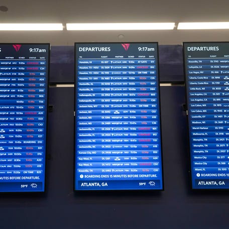 The departures board can be seen with many cancellations and delayed departures as travelers wait in long lines at Hartsfield-Jackson Atlanta International Airport on March 16, 2026, in Atlanta, Georgia.