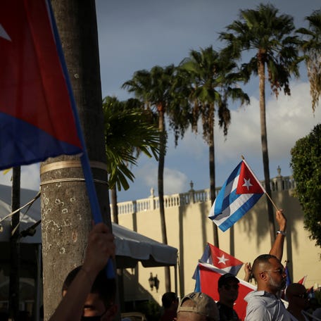 FILE PHOTO -- A man waves a Cuban flag as emigres gather outside Versailles restaurant, in reaction to reports of protests in Cuba against its deteriorating economy, in Miami, Florida, U.S. July 18, 2021. REUTERS/Marco Bello