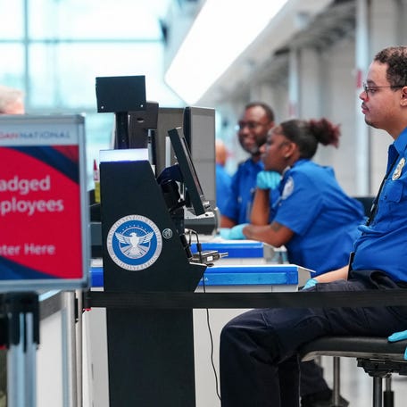 TSA agents work at a security checkpoint at Ronald Reagan International Airport in Arlington, Virginia., U.S., March 15, 2026.
