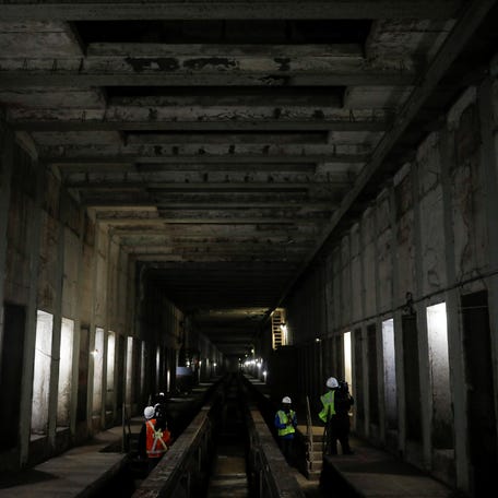 In this 2021 file photo, media members and workers from the Metropolitan Transportation Authority stand in a tunnel section during a tour of the site of the Second Avenue Subway tunnel expansion, a major infrastructure project in New York City.