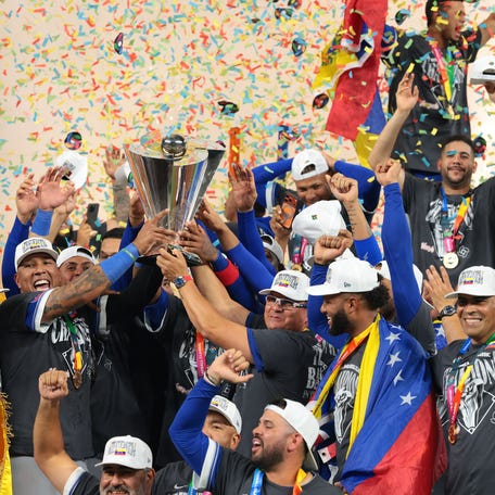 Venezuela players celebrate with the WBC trophy.
