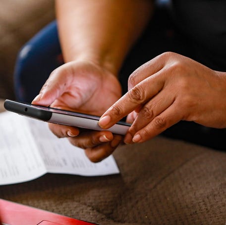 Christanine Brodis, 48, of Detroit talks on the phone with a representative from the Accounting Aid Society to help her file her 2020 taxes at her home on Feb. 13, 2021. Brodis lost her job as a personal home care provider and is struggling to get a tax refund from last year and she did not get one of her stimulus checks.    Tompor 021321 Kpm 1122
