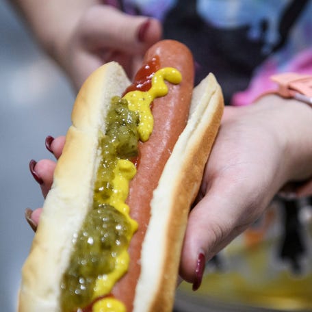Kimberly Hills displays the size of her $1.50 hot dog during Costco's grand opening day in Evansville, Indiana June 28, 2019.