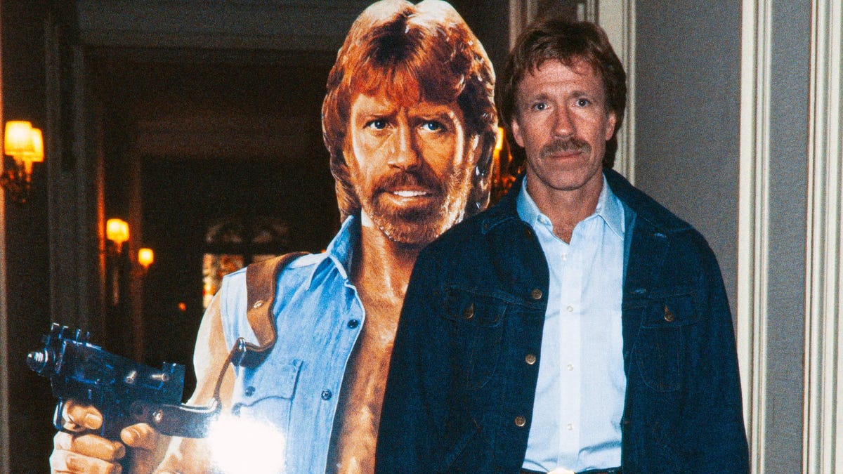Chuck Norris poses on Nov. 27, 1985 in front of the poster for the movie "Invasion USA" at the Hôtel Plaza Athénée in Paris.