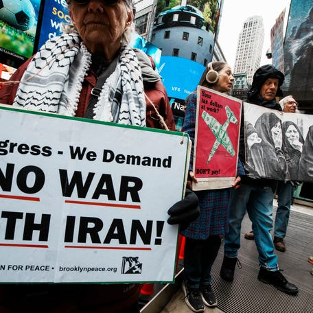 People attend a "No More War" protest marking the anniversary of the U.S.-led invasion of Iraq, outside a military recruiting station in New York City on March 19, 2026.