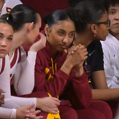 USC guard Juju Watkins, in red jacket, looks on from the bench.