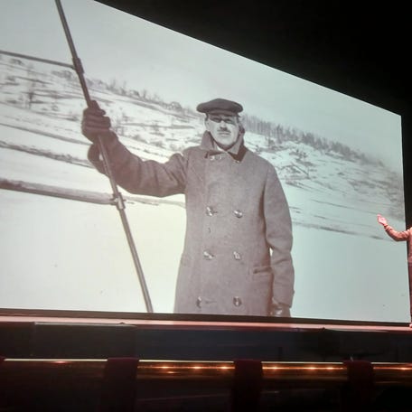 Emcee Maynard Okereke, founder of "Hip Hop Science Show," regards a photo of Robert Goddard at Goddard's famed rocket launch, at "Goddard Father of the Space Age," held March 22 at the Hanover Theatre & Conservatory for the Performing Arts.