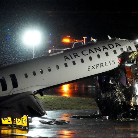 Debris hangs from a damaged Air Canada Express jet that had collided with a fire truck at New York's LaGuardia Airport in Queens, New York, U.S., March 23, 2026.