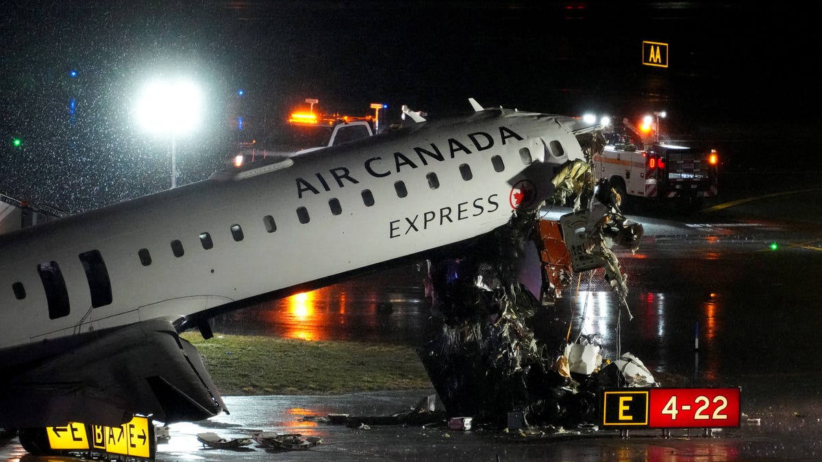 Debris hangs from a damaged Air Canada Express jet that had collided with a fire truck at New York's LaGuardia Airport in Queens, New York, U.S., March 23, 2026.