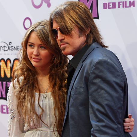 Miley Cyrus and Billy Ray Cyrus attend a premiere of "Hannah Montana: The Movie" in 2009 in Munich, Germany.