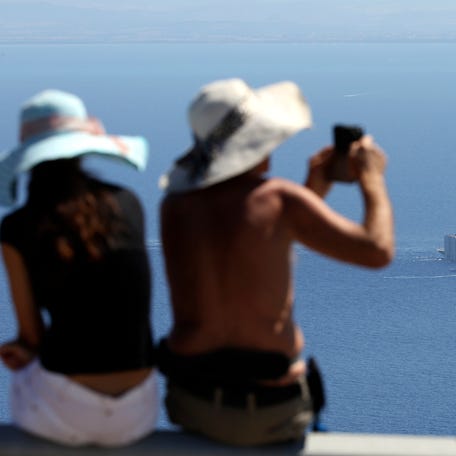 A woman takes a picture of the cruise liner Costa Concordia after it left Giglio Island July 23, 2014.