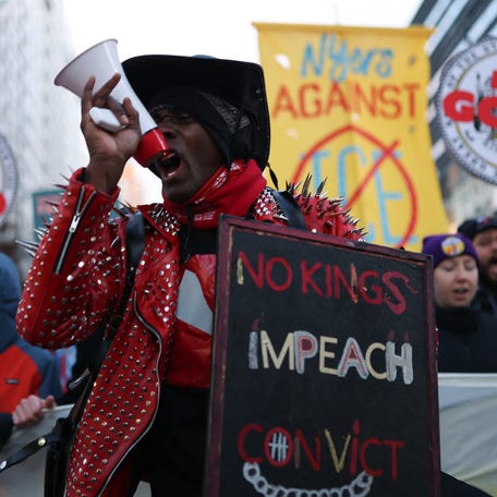 A protestor holds a "No Kings, Impeach, Convict" sign as people march during an "ICE Out" protest in New York on January 23, 2026 against US Immigration and Customs Enforcement (ICE). Demonstrations against ICE grew dramatically following the killing of Renee Nicole Good, 37, by an ICE officer in Minneapolis on January 7 as the Trump administration pressed operations to catch undocumented migrants. (Photo by ANGELA WEISS / AFP via Getty Images)