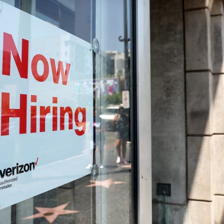 A "Now Hiring" sign is posted at a Verizon store in Los Angeles on July 26, 2022.