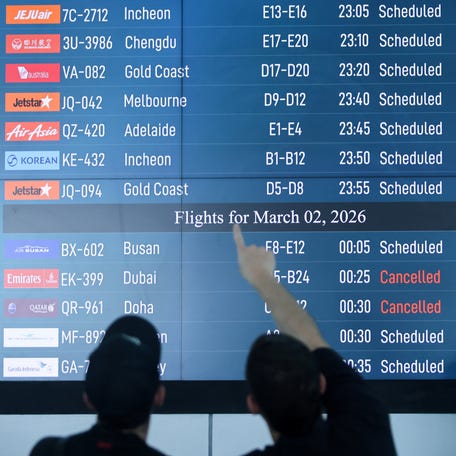 Passengers looks at departure board at I Gusti Ngurah Rai International Airport as some flights to Dubai and Doha cancelled following strikes on Iran launched by the United States and Israel, in Kuta, Bali, Indonesia, March 1, 2026.
