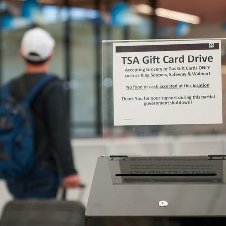 A traveler passes a donation box at Denver International Airport where people can drop off grocery and gas cards to help TSA workers who are going unpaid during the partial government shutdown.