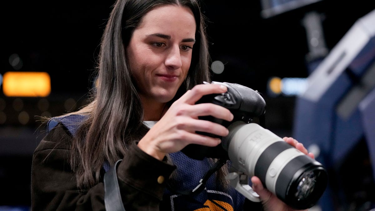 Indiana Fever guard Caitlin Clark takes photographs Wednesday, March 25, 2026, during a game against the Los Angeles Lakers at Gainbridge Fieldhouse in Indianapolis.