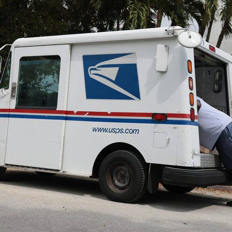 Postal carrier Marc Jacques delivers the mail in a neighborhood on March 19, 2026, in Miami, Florida. The head of the US Postal Service has warned lawmakers that it may run out of money in less than a year.