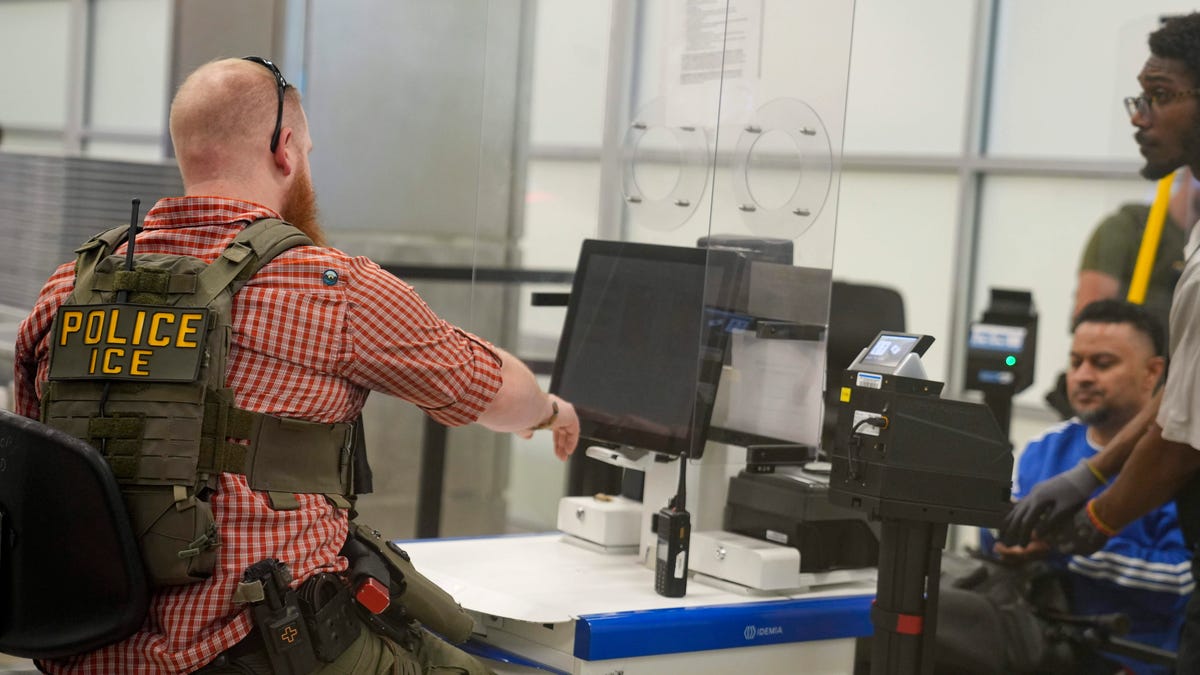 ATLANTA, GEORGIA - MARCH 26: An ICE agent checks ID's at the security check point in Atlanta Hartsfield-Jackson International Airport on March 26, 2026 in Atlanta, Georgia.The travel disruptions continue as hundreds of TSA agents quit or work without pay during a partial government shutdown. U.S. President Donald Trump said ICE agents will be deployed to U.S. airports on Monday, with border czar Tom Homan in charge of the effort.(Photo by Megan Varner/Getty Images)